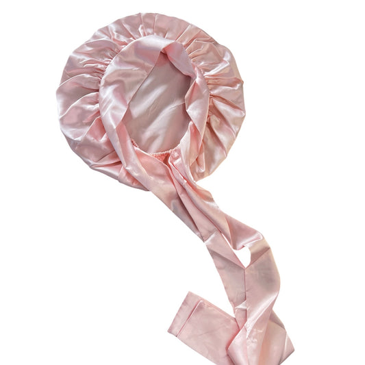 Pink silk hair bonnet on a white background