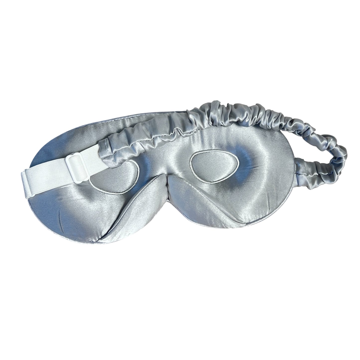 Silver silk eye mask with adjustable band on a white background