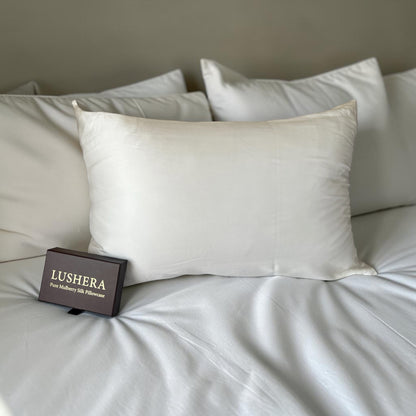 white Silk pillowcase with Lushera packaging on a bed