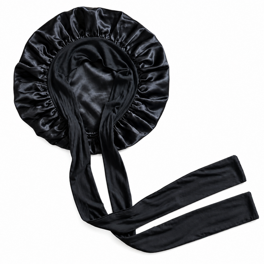 A black silk bonnet with long ties, displayed flat on a solid white background.