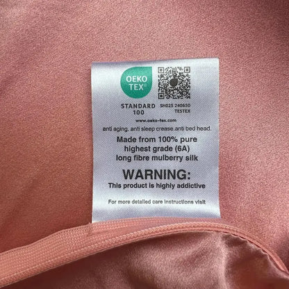 OEKO-TEX label on a pink fabric background with text and QR code.